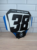 Custom motocross number plate replica with personalized rider number and name on a stand